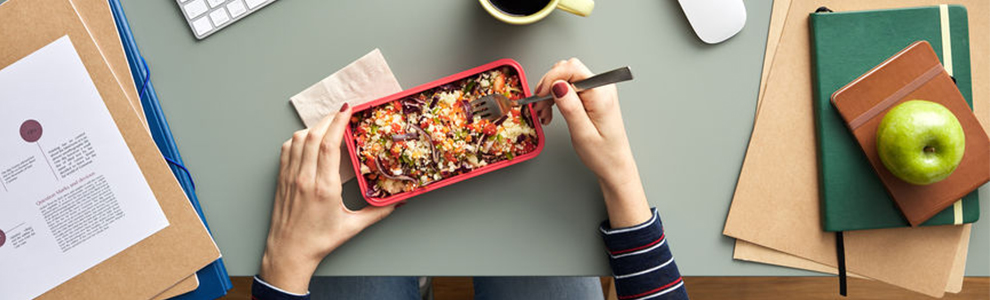 Woman eating vegan food at a desk